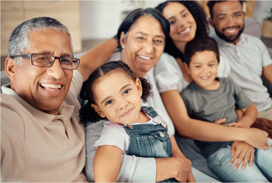Família reunida sorrindo no sofá